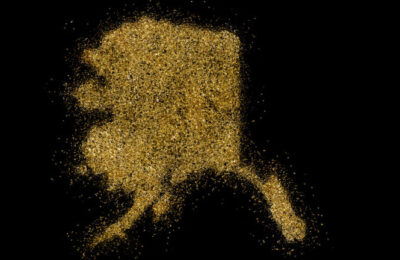 Alaska shaped from golden glitter on a black background (series)