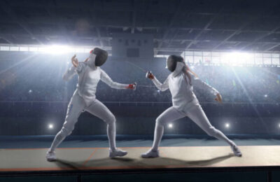 Fencing competitive duel. Female fencer fight on big professional stage. They are wearing an unbranded fencing suit.